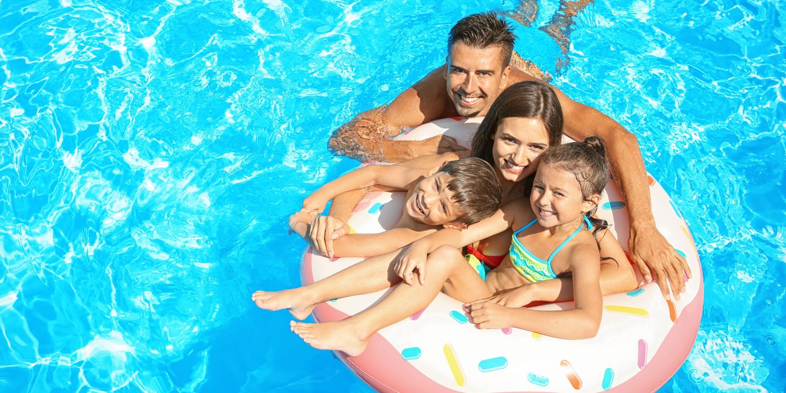 Family in pool on inflatable float/donut