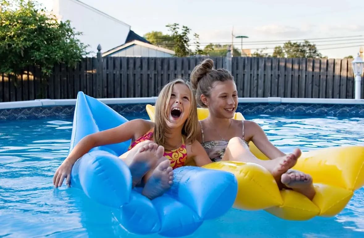 Two girls sitting on floaties